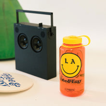 Load image into Gallery viewer, Be Happy 32oz Wide Mouth red Nalgene with yellow and black LA smiley face Don&#39;t Trip logo lifestyle image - Free &amp; Easy
