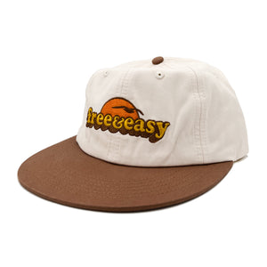Free & Easy bone and brown lightweight hat with orange, yellow and brown embroidered sun with bird logo on white background - Free & Easy